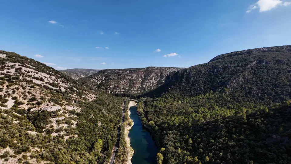 The Hérault River and a narrow road winding between rocky wooded slopes in southern France
