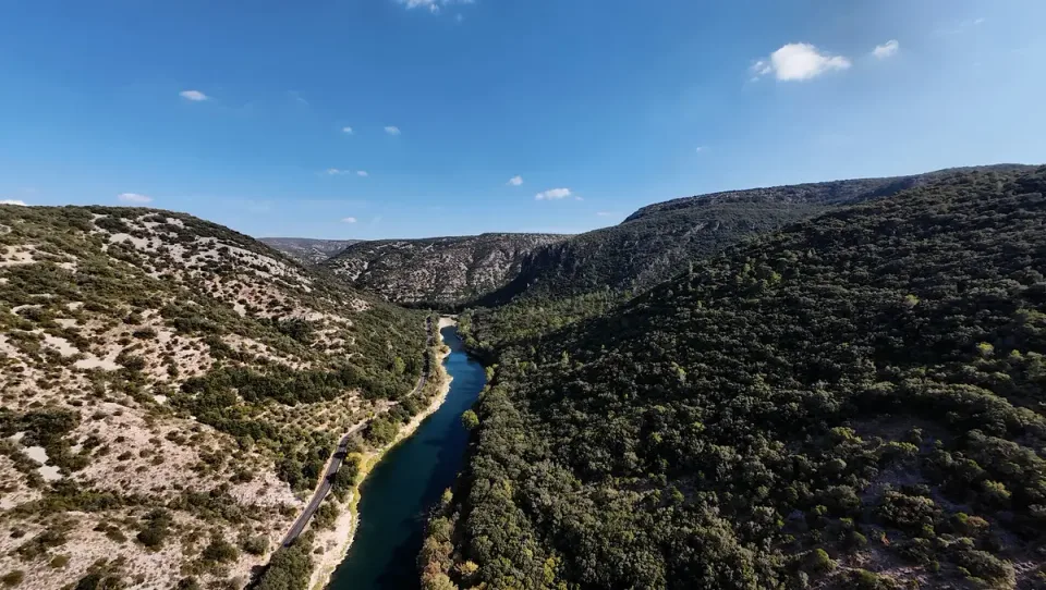 Elevated view of the Hérault River and a narrow road running between rocky wooded slopes
