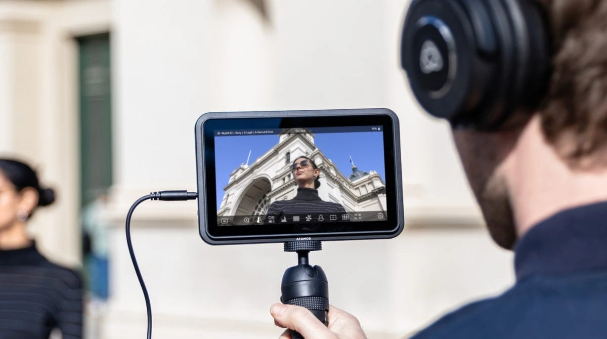 Official Atomos photograph of the Shinobi 7 II used as a handheld director's monitor outdoors