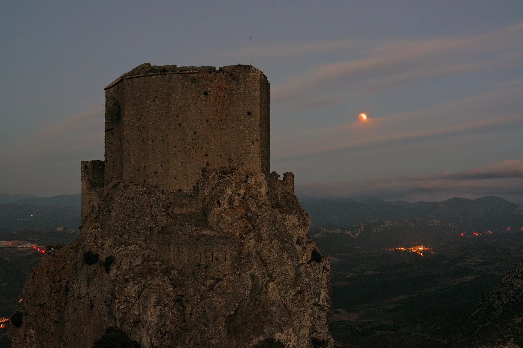 Partial lunar eclipse to the right of Quéribus Castle before sunrise in southern France